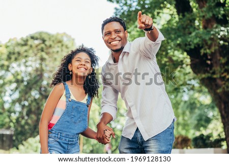 Father and daughter enjoying a walk together outdoors.