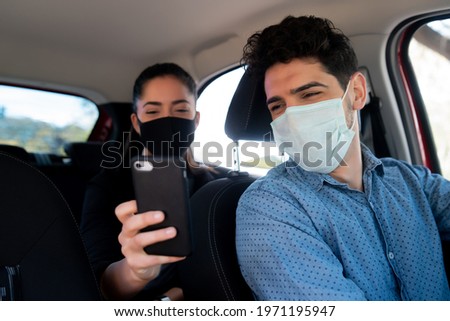 Woman showing something on phone to cab driver.