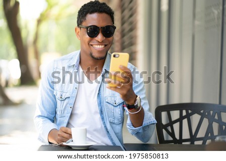 Man using his mobile phone at coffee shop.