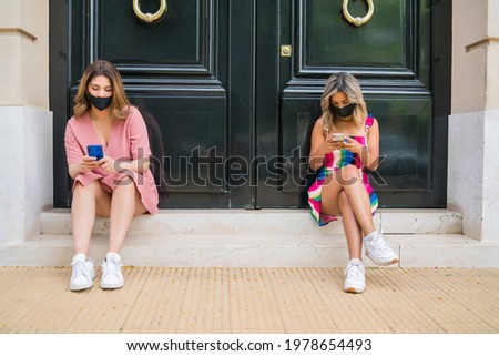 Two people wearing face mask and keeping distance outdoors