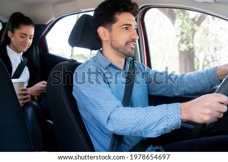 Taxi driver with passenger at back seat.