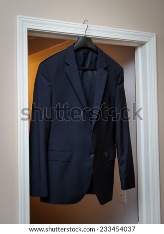 Groom\'s suit hanging on the door frame