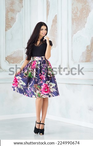 Portrait of young woman in skirt, in studio
