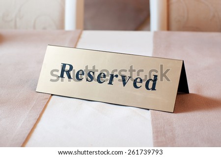 Reserved sign, reservation. On table. Beige