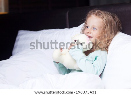 the little girl in bed with a toy