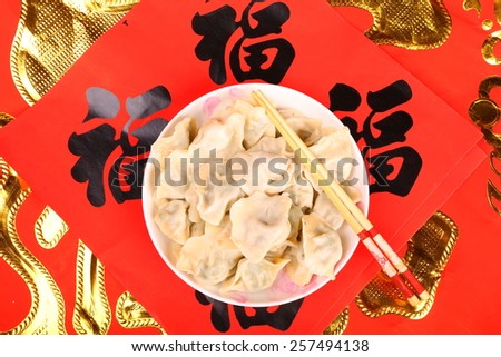 Chinese Jiaozi on traditional  spring festival couplets background