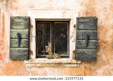 Antic window with shutters open. Decorations on the window shelf