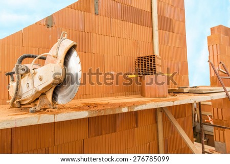 Brick by Brick,  build a house on your own. Building a home. Power tools on the dusty construction site. House under construction.