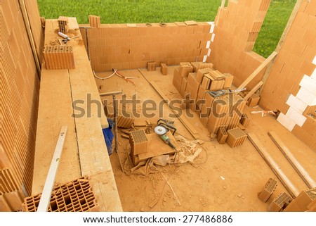 Brick by Brick,  build a house on your own. Building a home. Power tools on the dusty construction site. House under construction