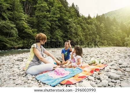 Family picnic by the river. Rapids and the forest in the background