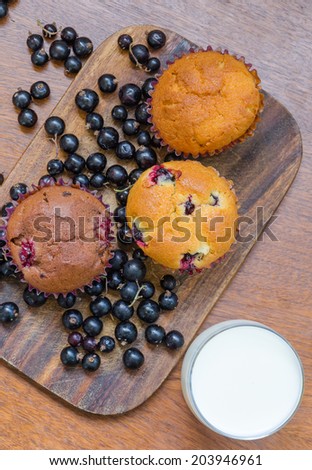 overview of three muffins with blackcurrant and a glass of milk