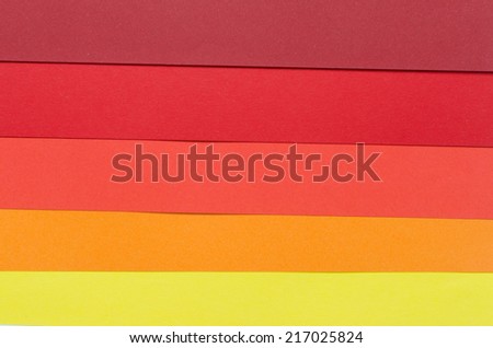 warm-colored construction paper sheets arranged horizontally