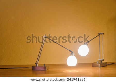 two lamps inspecting something on a table