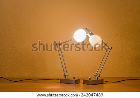 two lit table lamps supporting each other