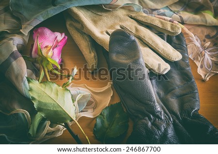 poetic composition with gloves and a rose in vintage look