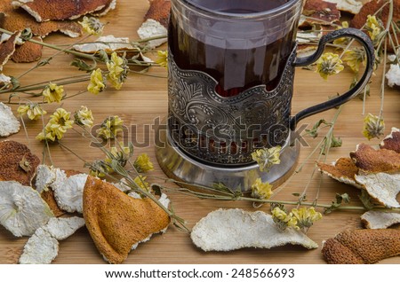 retro tea cup in between dried citrus peel and flowers on wooden table