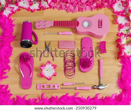top view of a collection of useful and playful pink objects on wooden floor