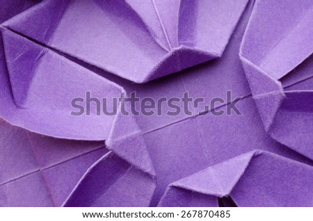 Abstract closeup of a purple paper origami flower. Top view.