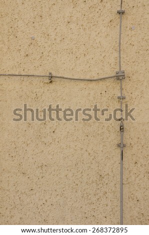 connected wires mounted to a textured exterior wall