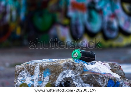 Graffiti spray can in front of graffiti wall