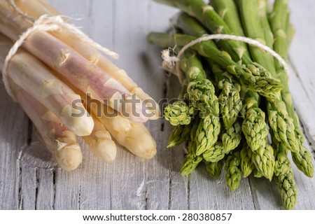 bunch of green and white asparagus on white wooden background, closeup