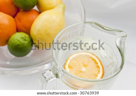 A bowl of citrus fruits and a carafe of water