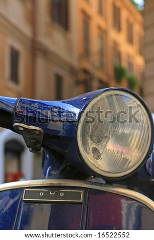 Italian motorbike/scooter in Rome,Italy with buildings to background.