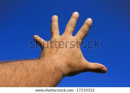 A male hand and forearm pointing skywards with fingers outstretched out and reaching. Set against a bright blue sky background.