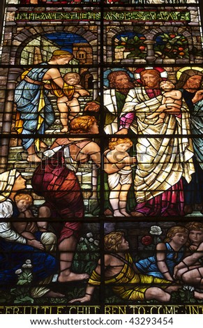 A low angled image of a stained glass window from Salisbury Cathedral in wiltshire UK. Scene depicts - Suffer the Little Children to Come Unto Me.
