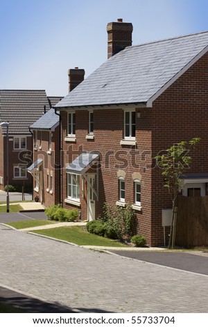 A new modern housing development. A row of recently built new houses constructed of red brick with grey slate roofing. location in Salisbury, Wiltshire.