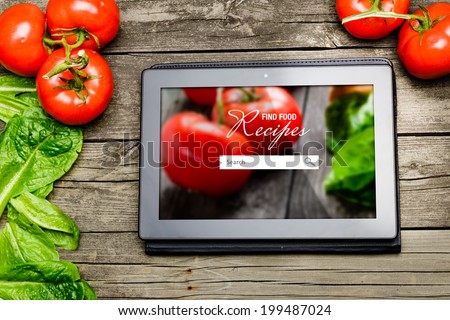 Cooking recipes on tablet pc with vegetables on background.