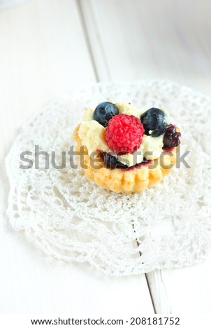 Tasty mini cake with fresh raspberries and blueberries