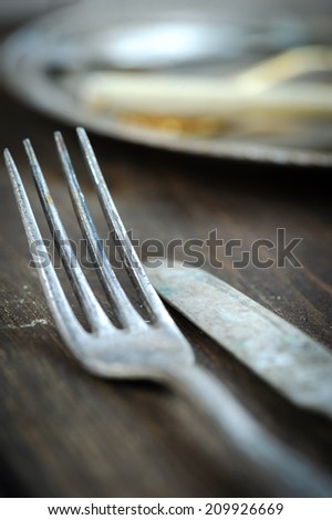 Vintage knife and fork on blue linen napkin over wooden table