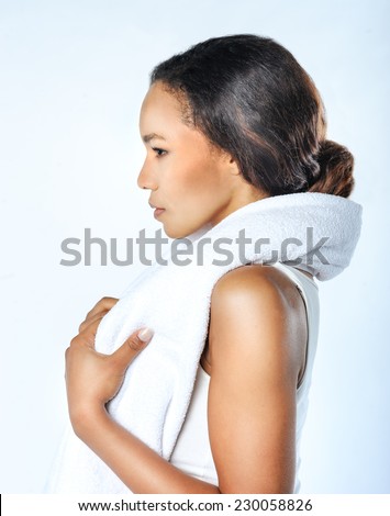 Cheerful confident young black woman with towel after gym portrait. Profile. Sexy fit woman posing with towel