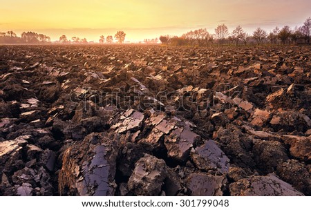 plowed soil. spring field. sunset over ploughed field. Countryside lanscape