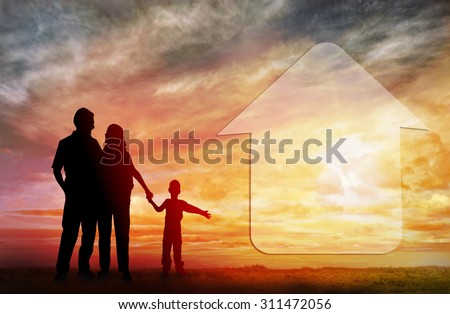 Family dream about a new house. Family house. Silhouettes against sun set.