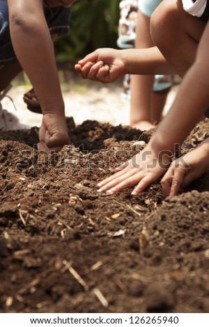 young children planting seeds in garden