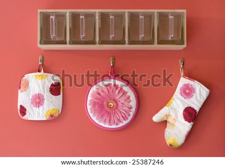 A fun glass organizer with colorful flower oven mitt and potholder.