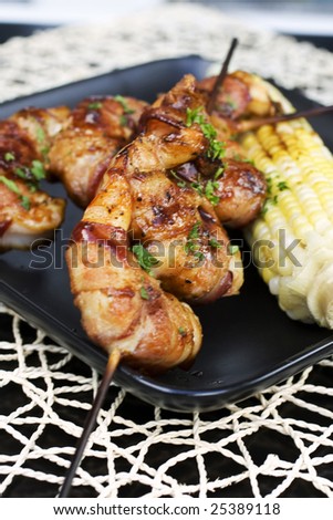 Skewers of bacon-wrapped shrimp at an outdoor dinner party.