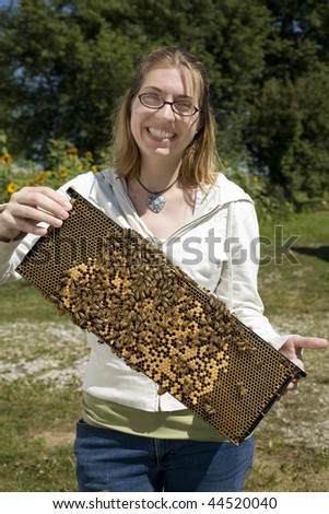 Woman holding bee hive frame