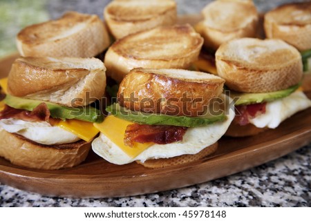 Fried egg sandwiches with avocado, bacon and cheese