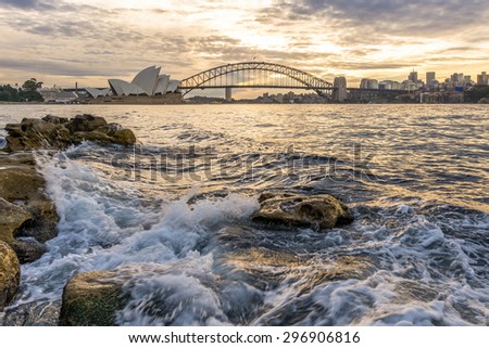 The sun sets behind the Harbour Bridge and Opera House in Sydney.