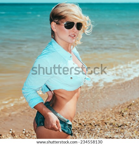 pretty woman in sexy shorts posing at beach. Fashion summer outdoor portrait. pretty woman in sexy shorts posing at beach. Fashion summer outdoor portrait