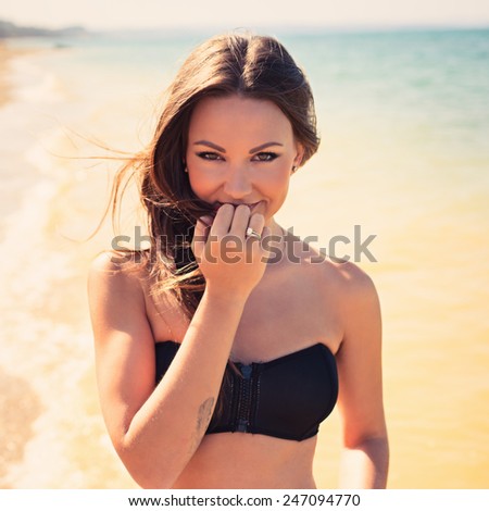 Woman with beautiful body on a tropical beach. beautiful young woman in a black bathing suit relaxing on the beach. Hipster style