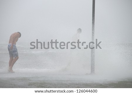 BRISBANE, AUSTRALIA - JANUARY 27 : Unidentified men brave the elements during ex tropical cyclone Oswald on January 27, 2013 in Brisbane, Australia