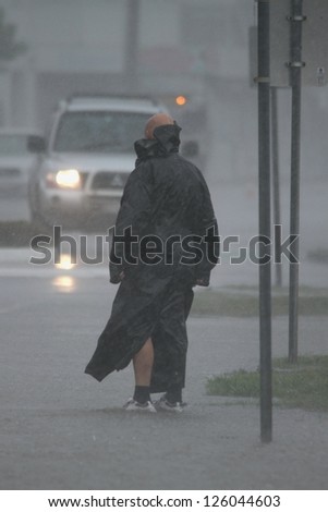 BRISBANE, AUSTRALIA - JANUARY 27 : Unidentified man braves the elements during ex tropical cyclone Oswald on January 27, 2013 in Brisbane, Australia