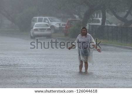 BRISBANE, AUSTRALIA - JANUARY 27 : Unidentified woman sings in the rain during ex tropical cyclone Oswald on January 27, 2013 in Brisbane, Australia