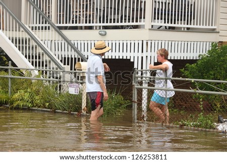 BRISBANE, AUSTRALIA - JANUARY 28 : Unidentified residents chat in flood waters from ex tropical cyclone Oswald on January 28, 2013 in Brisbane, Australia