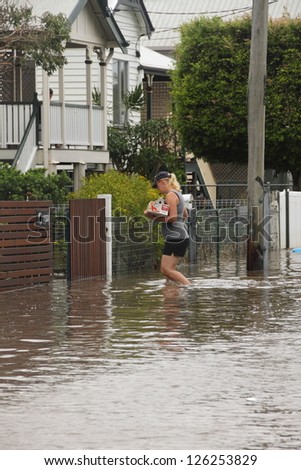 BRISBANE, AUSTRALIA - JANUARY 28 : Unidentified resident taking groceries through flood waters from ex tropical cyclone Oswald on January 28, 2013 in Brisbane, Australia