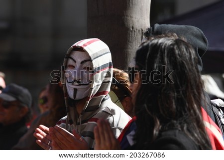 BRISBANE, AUSTRALIA - JULY 06 : Unidentified protester wearing anonymous mask at Bust The Budget anti liberal governement Rally July 06, 2014 in Brisbane, Australia